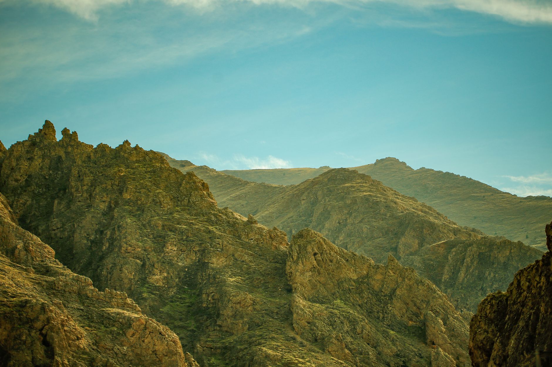 A panoramic view of a rugged rocky landscape beneath a clear blue sky, capturing the essence of a summer hike.