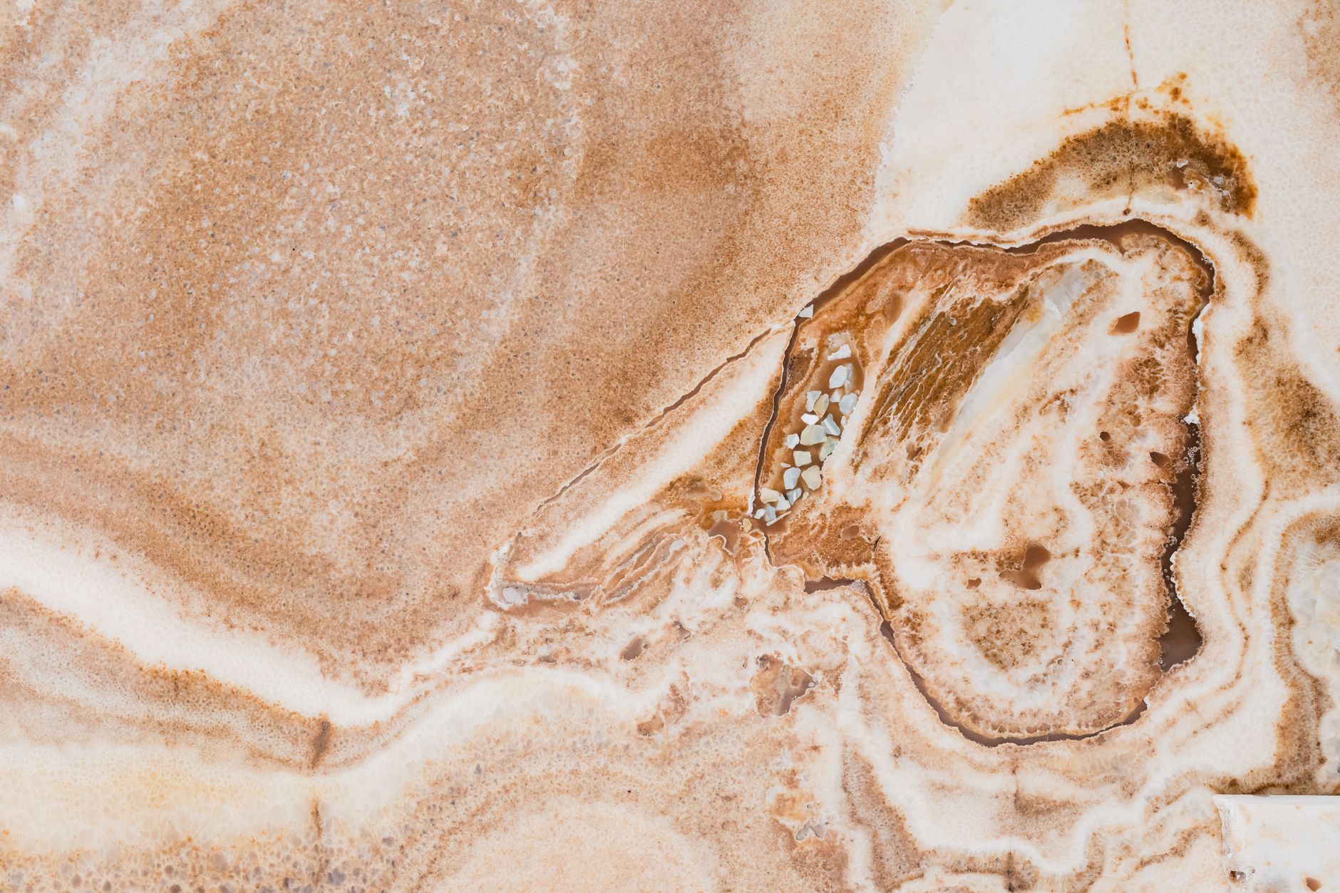 a close up of a rough agate stone showing waxy luster on a gray surface