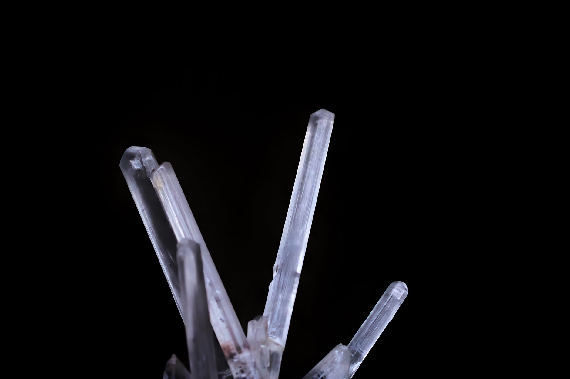 a clear quartz crystal cluster sitting on gray rock surface