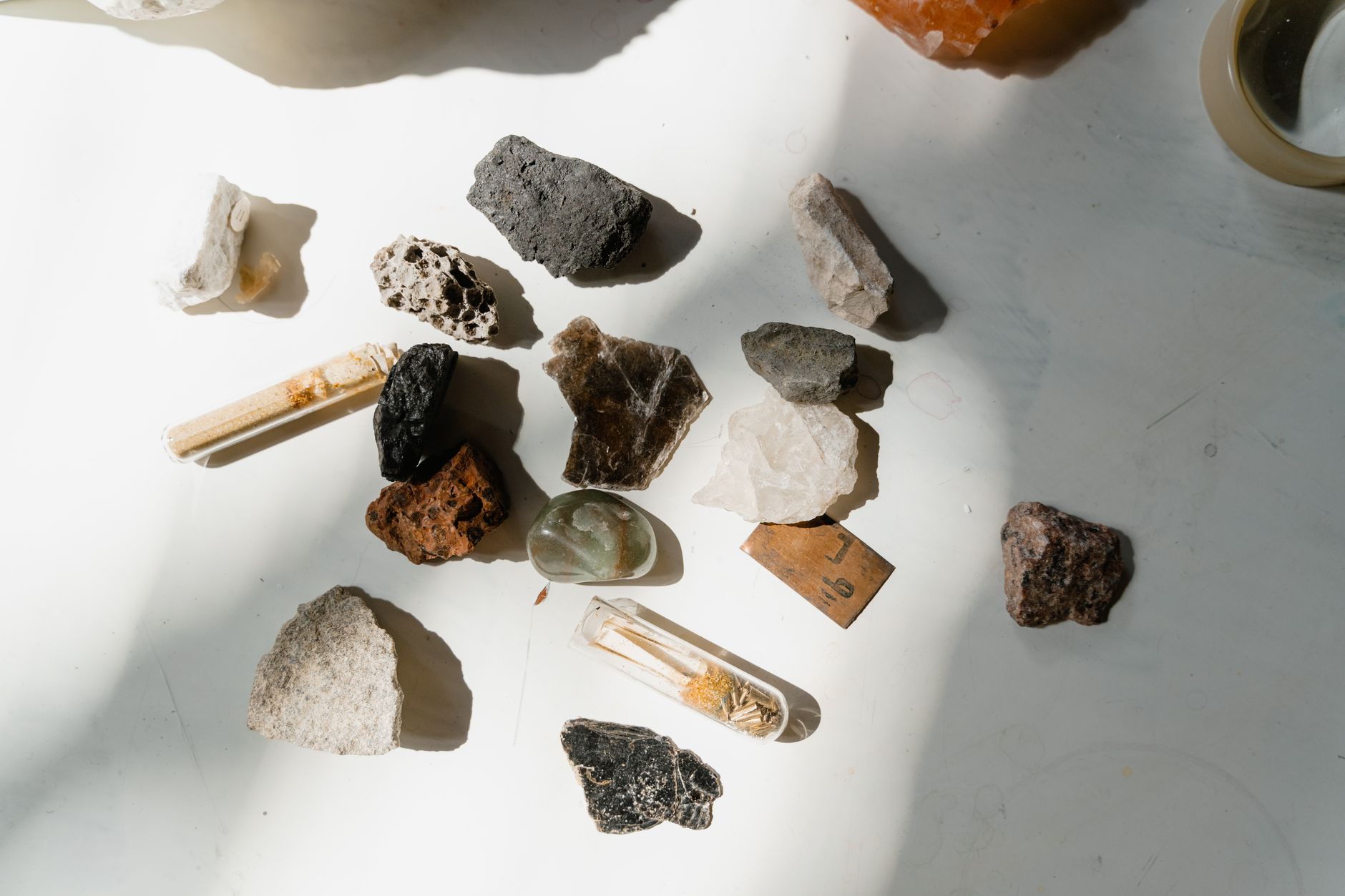 a person cleaning rock and mineral specimens with a brush and water on a workbench