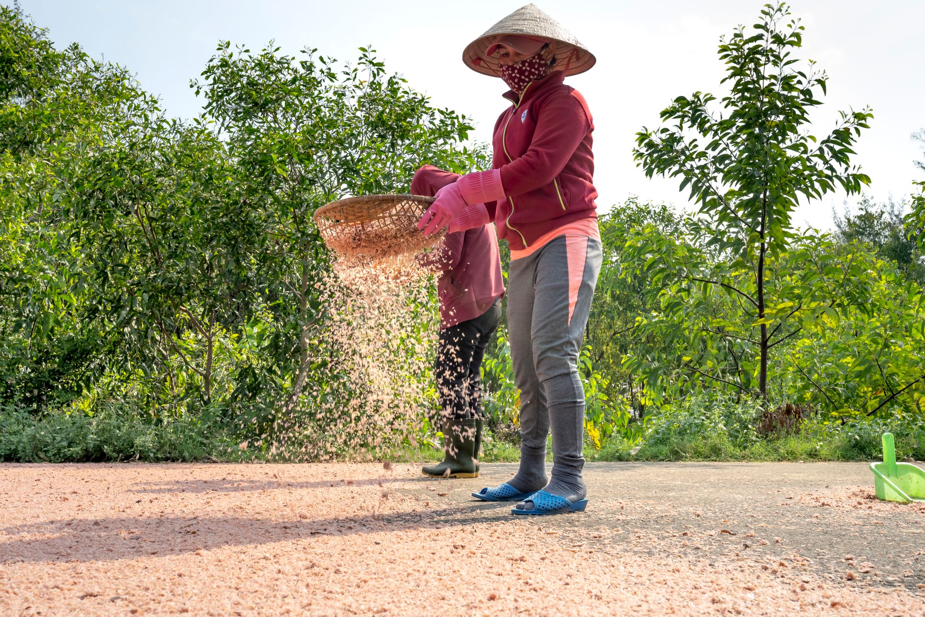 a person shaking a wooden sifting screen in shallow river water